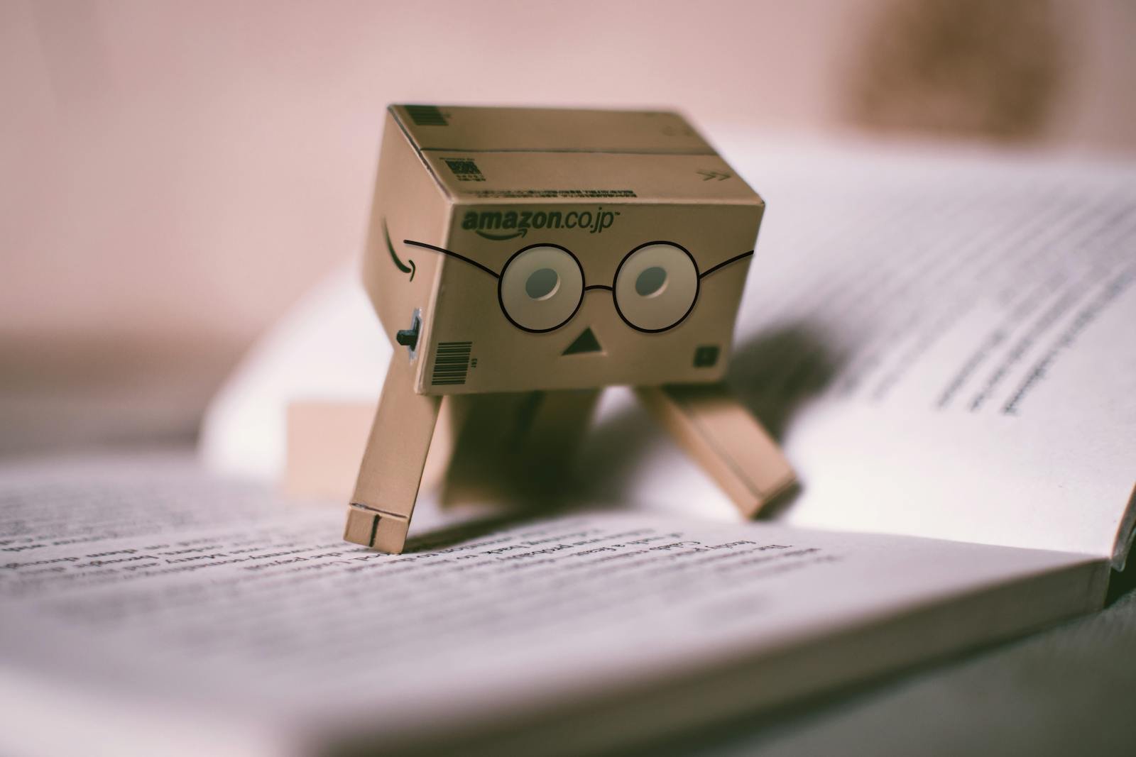 Close-up of a Danboard toy with glasses on an open book, creating a whimsical study scene.